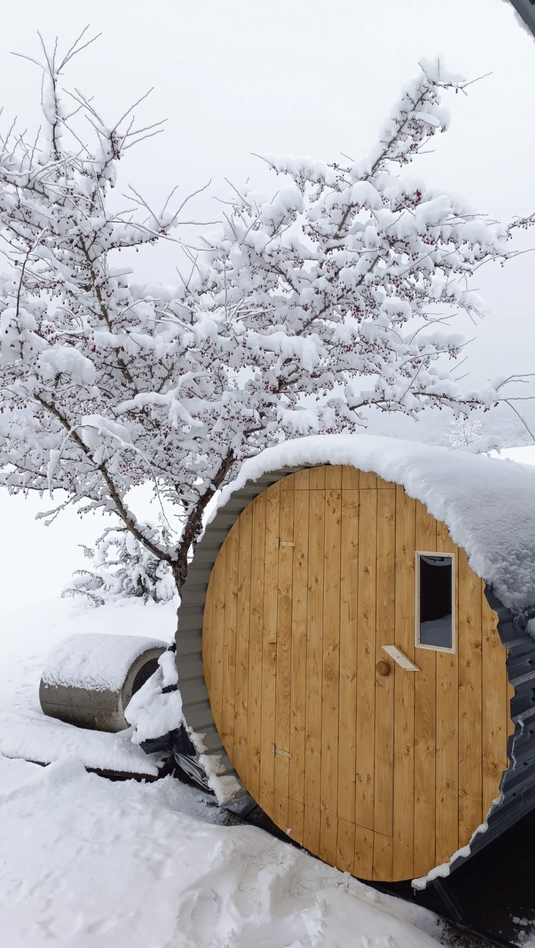 Hordó formájú szauna a Harmónia Kempingben, téli hóval borított környezetben